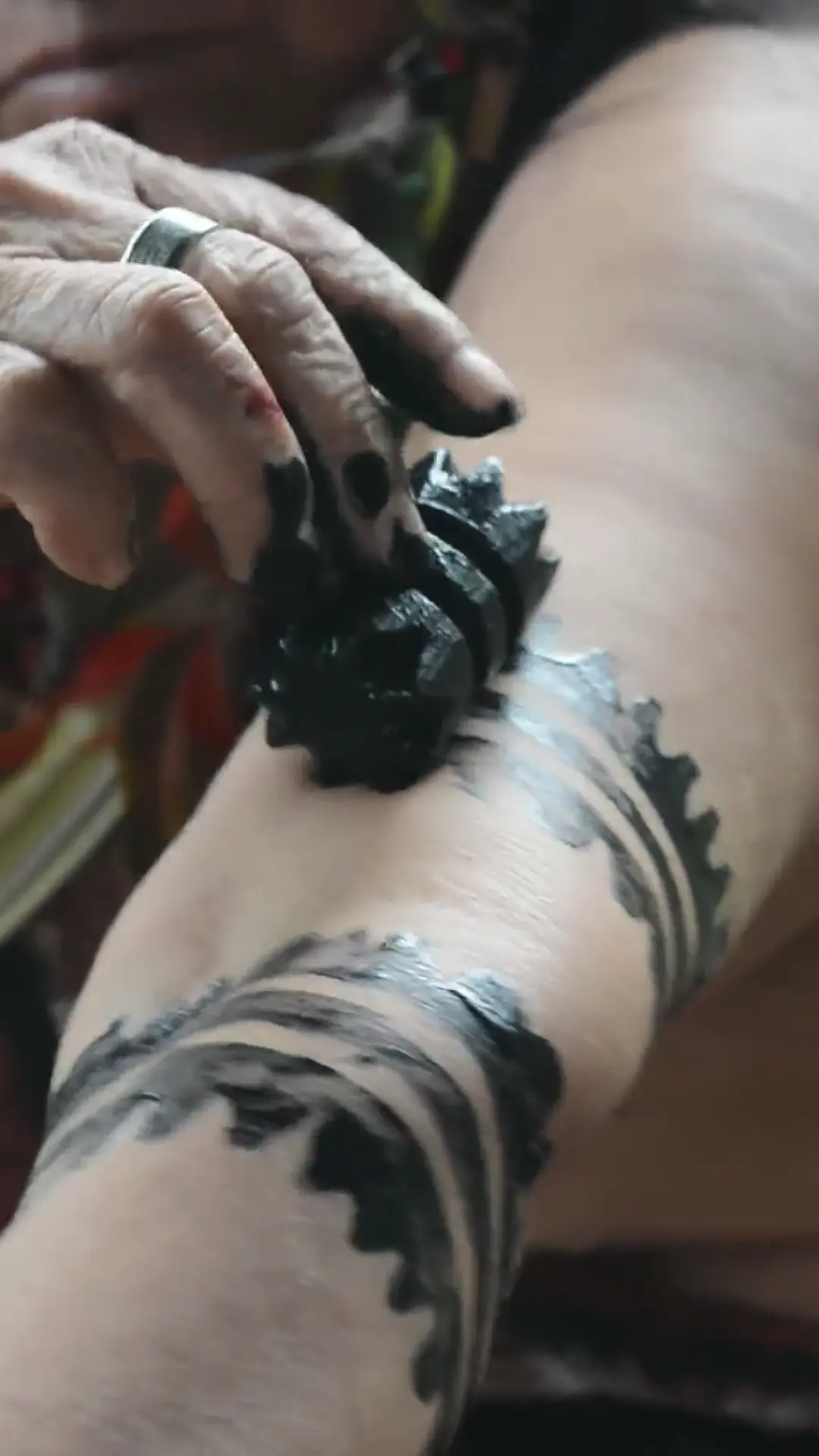 Pintura corporal con patrones geométricos ancestrales sobre el brazo