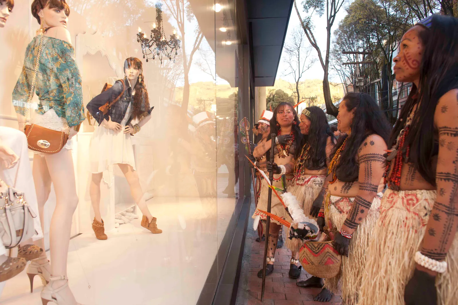 Mujeres Tubú en traje ancestral frente a una vitrina en la ciudad